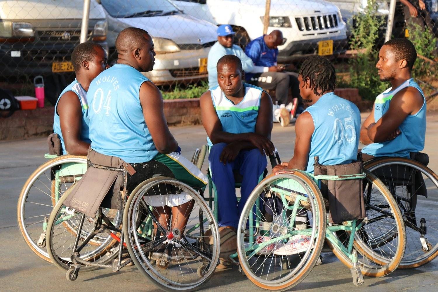 Wheelchair basketball players talking courtside between games